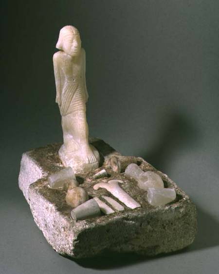 Implements and vessels on an altar-shaped slab with standing figure Egyptian from Anonymous
