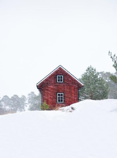 Altes rotes Haus während des Schneesturms