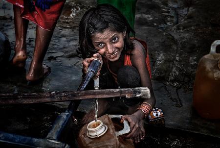 Rohingya-Flüchtlingsmädchen füllt einen Behälter mit Wasser – Bangladesch
