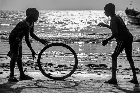 Afrika-Kinder spielen mit altem Rad