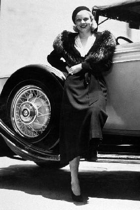 American Actress Jean Harlow posing near a car