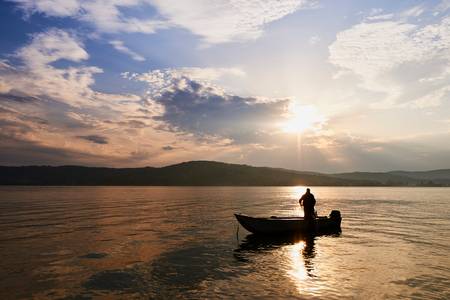 Ein Fischer auf dem Boot im romantischen Morgenlicht