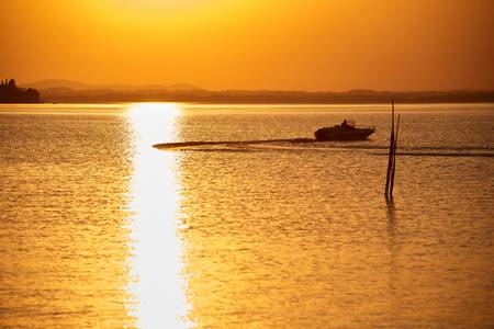 Goldgelbes Abendlicht am romantischen Lago Trasimeno See mit einem Boot