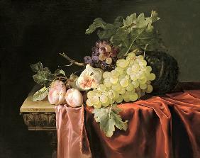 A still life with grapes, plums, figs and a melon on a partly draped stone ledge